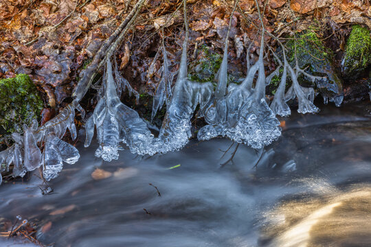 whitewater stream in winter, long exposure, water mist forms ice sculptures on the bank with phascinating light effects