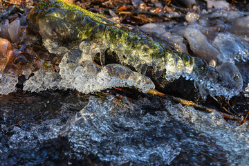whitewater stream in winter, long exposure, water mist forms ice sculptures on the bank with phascinating light effects