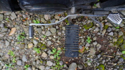 Motorcycle Footpeg with Worn Black Rubber - Close-up with Blurred Background