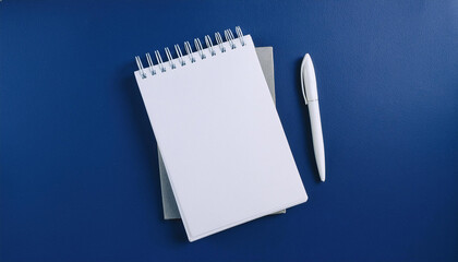 Blank notepad and pen on trendy dark blue background. Notebook for ideas message, list