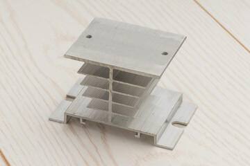 Aluminum heatsink with a base and fins on a wooden surface