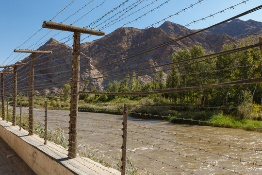 Border view between Armenia and Iran along the Aras river with a fence