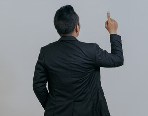 Rear view Asian boss manager businessman pointing finger up, isolated over white background.