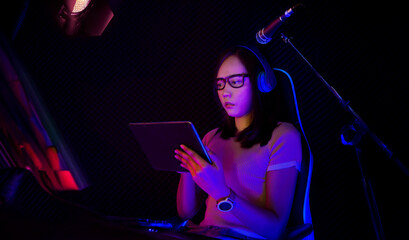 Asian woman, seated at a tablet, expresses concern over her declining online popularity as she...