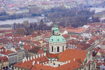 Obraz premium A breathtaking aerial view of a historic European city with a grand church, red rooftops, and a river weaving through the landscape