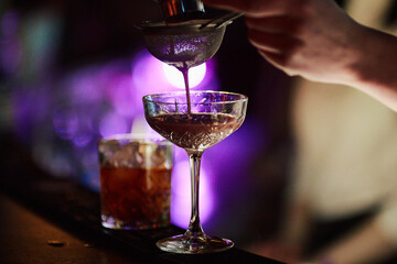 Bartender Preparing Cocktails at a Bar Counter
