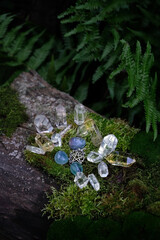 quartz minerals and amulet in forest, dark natural background. Gemstones for Magic Crystal Ritual,...