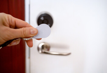 A hand with keys opening a digital door lock