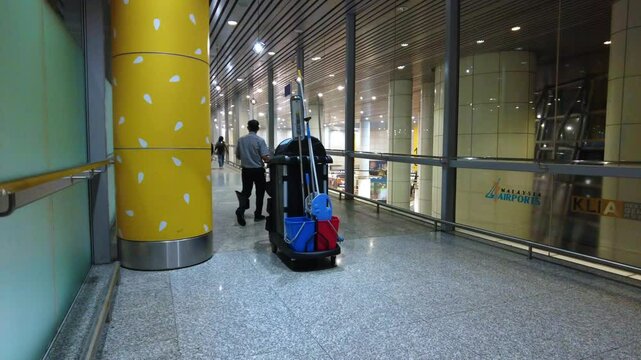 Sepang, Malaysia, December 5, 2024 Cleaner is sweeping the floor as he is making a round through the KLIA airport.
