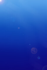 Abstract blue colored background with soft highlights and lens effects. Gradient transition from light blue to rich dark blue. Minimalist business presentation background