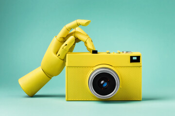 Yellow vintage film camera with hand on color pastel background.