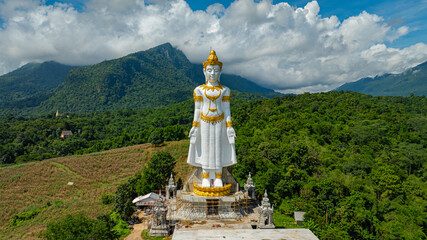 Big Buddha Brahma Panyo standing tall in front of Doi Luang mountain, Chiang Mai symbolizing peace...