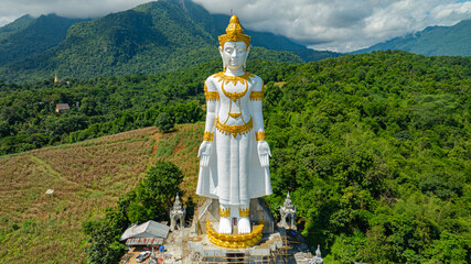 Big Buddha Brahma Panyo standing tall in front of Doi Luang mountain, Chiang Mai symbolizing peace...