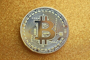 Bitcoin coin on abstract yellow glitter sparkle confetti background