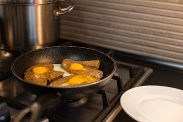 Fried eggs with bread in a pan. Cooking breakfast.