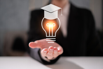 Hand holding light bulb lamp with graduation hat new idea inspiration education graduation concept