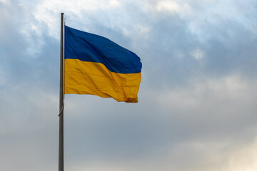 Ukraine flag waving sign independence symbol on a pillar with dramatic natural light cloudscape