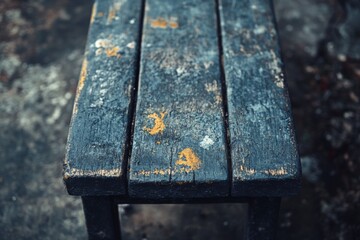Fototapeta premium Close-up of a wet wooden park bench with autumn leaves on its surface
