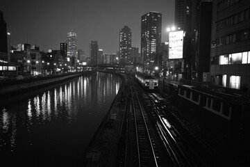 Black and white photo of a cityscape with train tracks leading into the skyline