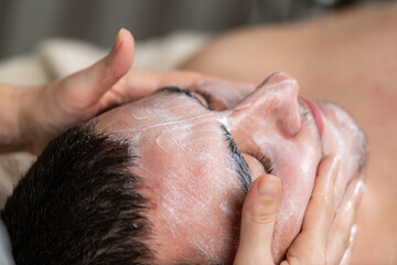 Naklejka premium Man receiving a professional facial cosmetic treatment, focusing on skincare, rejuvenation, and relaxation. Modern techniques for healthy, refreshed, and youthful skin.