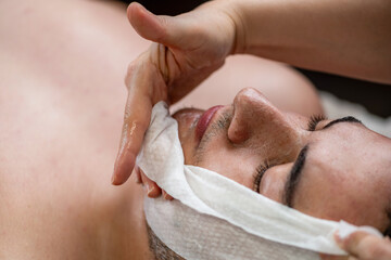 Man receiving a professional facial cosmetic treatment, focusing