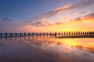 Old sea defence groynes used to protect coastlines from erosion at sunset. Walney, Lake District,...
