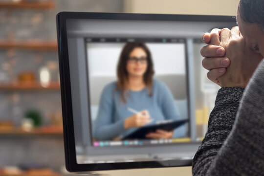 Man having online meeting in video call and talking to his colleague. Professional man solving problems during an online meeting at home, seated by a computer monitor, showcasing virtual communication