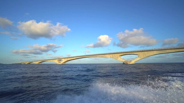 Construction of a railway bridge over the ocean. The structural elements come together to form a complete bridge. The camera moves towards the construction site.