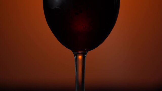 Tasting red wine. Glass of red wine slightly shaking against vineyard background. Winemaking in California, USA. Slow motion shot, 4K