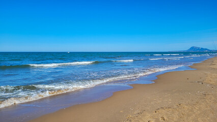 Scenic Mediterranean beach with mountain view in Gandia, Spain