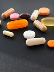 Multicolored pills and capsules with medicines lie on the table close-up, top view