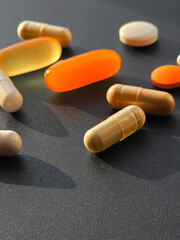 Multicolored pills and capsules with medicines lie on the table close-up, top view
