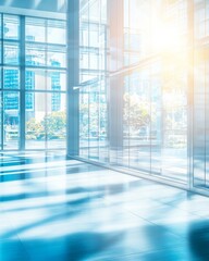 Bright, blurred background of a modern office interior with glass walls and floor, in a blue color, with sunlight streaming through the windows. A business concept