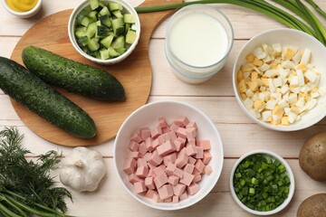 Fresh ingredients for okroshka soup on light wooden table, flat lay