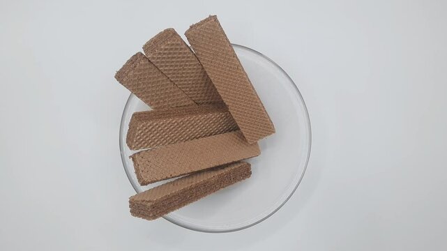 Isolated white several chocolate flavored wafer bars in a clear glass bowl  