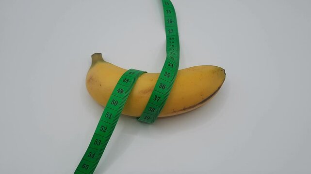Yellow banan a with measurement tape on white background
Male genitalia size concept