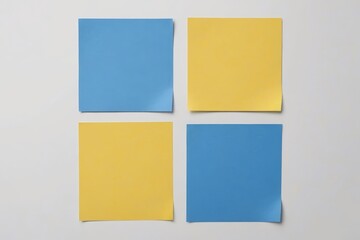 Fototapeta premium four pieces of yellow and blue paper are placed on a white surface