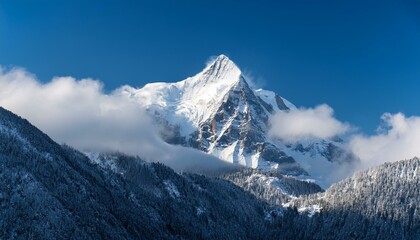 Obraz premium snow covered mountain peak rises above clouds