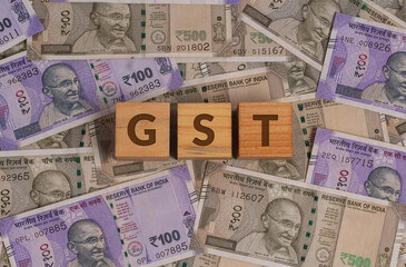 GST Word on Wooden Cubes with Indian Currency Background | Financial Growth Concept