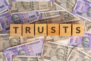 Trusts Word on Wooden Cubes with Indian Currency Background | Financial Growth Concept