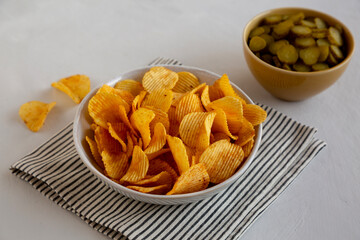 Crinkle Potato Chips and Green Pickle Chips in Bowls, side view.