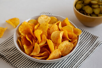 Crinkle Potato Chips and Green Pickle Chips in Bowls, side view.