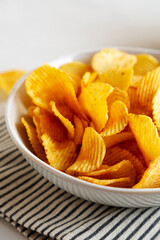 Crinkle Potato Chips in a Bowl, side view. Close-up.