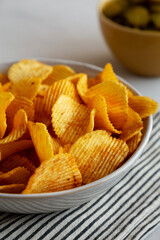 Crinkle Potato Chips and Green Pickle Chips in Bowls, side view.
