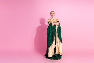 Fototapeta premium Elegant woman in period costume standing against vibrant pink background representing historical and royal themes