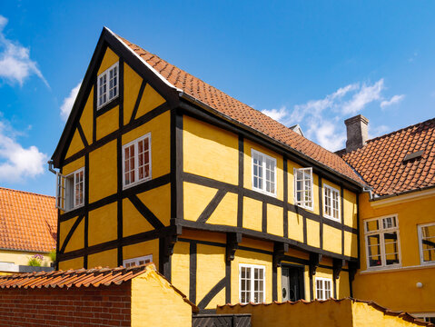 Half-timbered yellow two-level house with red-tiled roof in old town of Svendborg, Funen Island, Southern Denmark