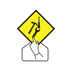 Person holding a yellow diamond shape with working tools on it
