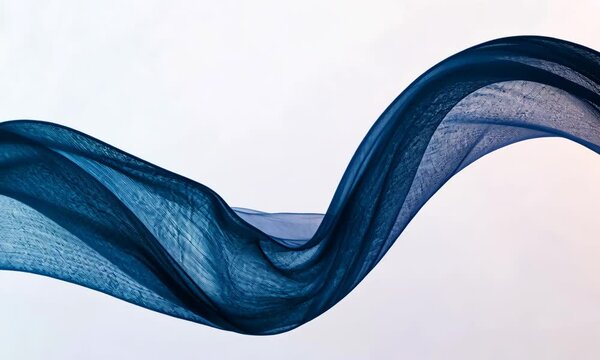 An artistic shot of flowing blue fabric gracefully moving, showcasing its delicate texture and form against a minimalist background, evoking feelings of fluidity and motion.