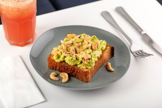 Avocado toast with seed and cashew nuts on breakfast table