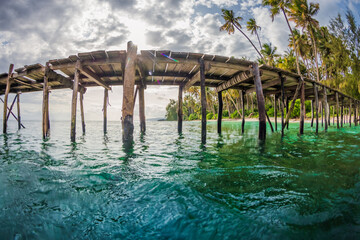 Tropical coast line with wooden pier in quiet sea in Indonesia. Fisheye shot